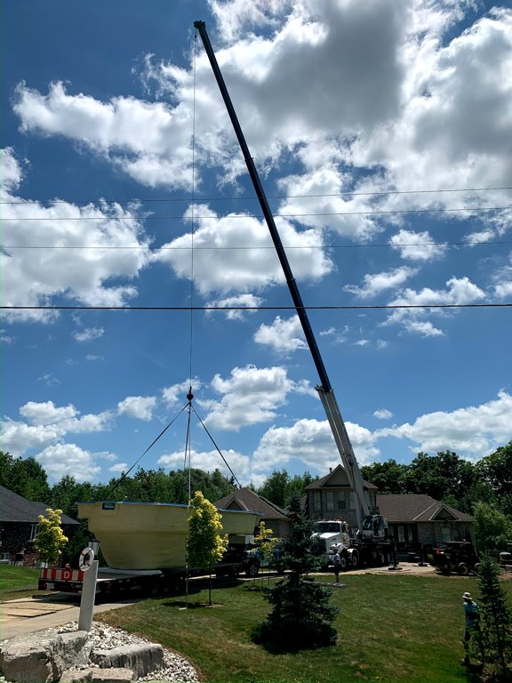 A fiberglass pool being craned