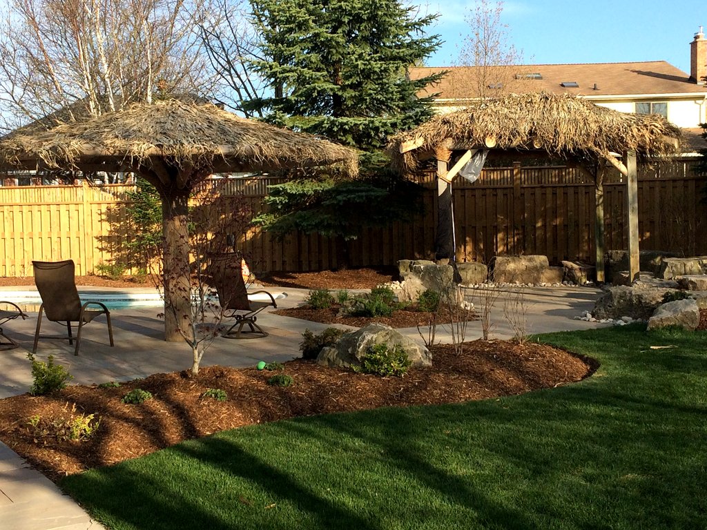 Tropical backyard around pool and patio installed in Guelph
